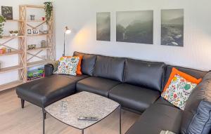 a living room with a leather couch and a table at Awesome Home In Thyborøn With Wifi in Thyborøn