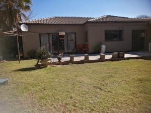 a house with a dog sitting in the front yard at Iris Bnb on Vaal in Vanderbijlpark