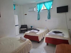 a room with two beds and a television in it at Hostal Marysol in Puerto Ayora +27 photos