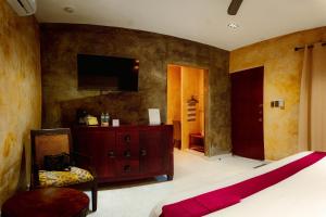 a bedroom with a bed and a tv on the wall at Petra By Ariché in Valladolid