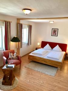 a bedroom with a bed and a couch and a table at Hotel Schwarzer Adler in Pettneu am Arlberg