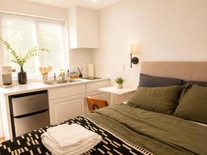 a bedroom with a bed and a kitchen with a sink at Tiny Studio in Orange Garden in Los Angeles