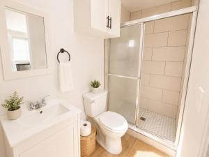 a white bathroom with a toilet and a shower at Tiny Studio in Orange Garden in Los Angeles +11 photos