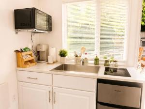 a kitchen with a sink and a microwave at Tiny Studio in Orange Garden in Los Angeles