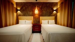 two beds sitting next to each other in a room at Petra By Ariché in Valladolid +22 photos