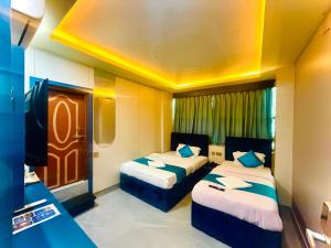 a hotel room with two beds and a television at Guru hotel and lodge in Itahari