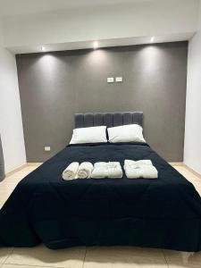 a large bed with two pairs of towels on it at Serena Suites in Ezeiza