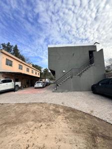 a building with cars parked in a parking lot at Serena Suites in Ezeiza