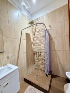 a bathroom with a shower with a purple towel at Serena Suites in Ezeiza