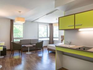 a living room with a couch and a table at Adagio Access Grenoble Université in Saint-Martin-dʼHères
