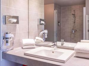 a bathroom with a sink and a shower at Adagio Access Grenoble Université in Saint-Martin-dʼHères
