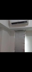 a tv sitting on top of a white shelf at osaka riverview apartment in Rawalumpang