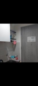 a bathroom with a door and a sink in a room at osaka riverview apartment in Rawalumpang