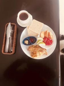 a table with a plate of food and a cup of coffee at Guru hotel and lodge in Itahari