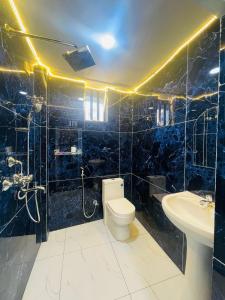 a bathroom with a toilet and a sink at Guru hotel and lodge in Itahari
