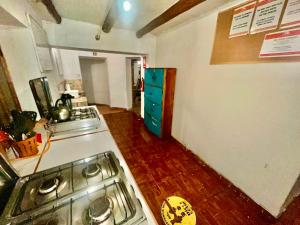 a kitchen with a stove and a counter top at Intihuatana Hostel in Pisac