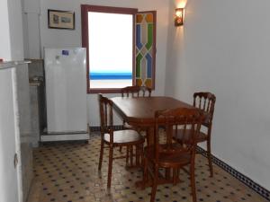 a dining room with a table and chairs and a window at Petit Bijou de Tanger in Tangier