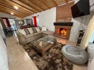a living room with a couch and a fireplace at Descanso Cuchilla Alta in Cuchilla Alta