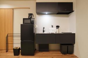 a kitchen with a sink and a refrigerator at 別府の宿 結 -Yui- in Beppu