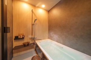 a bathroom with a tub and a toilet at 別府の宿 結 -Yui- in Beppu +18 photos