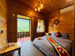 a bedroom with a bed in a wooden cabin at TaVan Eco Home in Tả Van
