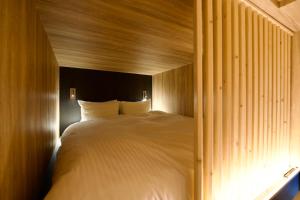 a bedroom with a large white bed with wooden walls at Grand Success Kotoni ll in Sapporo