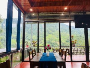 a dining room with a table with flowers on it at TaVan Eco Home in Tả Van