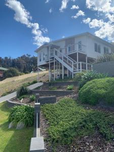 a white house with a cross in the yard at Kuruwa in Tathra