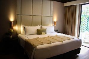 ein großes weißes Bett in einem Zimmer mit Fenster in der Unterkunft Hippodrome Hotel in Mexiko-Stadt