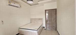 a small white room with a bed in it at AlSeef 161 in Al Sharqiyah