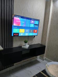 a flat screen tv sitting on top of a black entertainment center at Carley Studio apartment in Thika