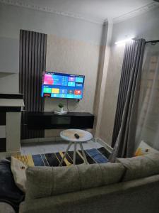 a living room with a couch and a tv at Carley Studio apartment in Thika