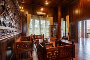 a living room with wooden chairs and a window at Heritage Village Resort in Kampot