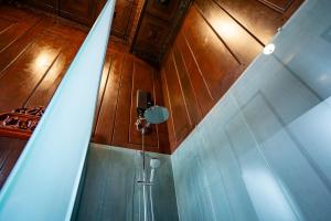 a bathroom with a shower in a room with wooden walls at Heritage Village Resort in Kampot