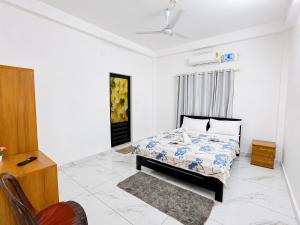 a bedroom with a bed and a chair in it at Zayan Home Stay in Agatti Island