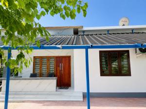 a small white house with red doors at Zayan Home Stay in Agatti Island