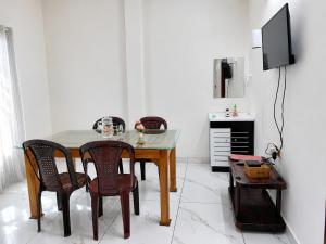 a dining room table with chairs and a television at Zayan Home Stay in Agatti Island