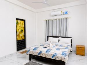 a bedroom with a bed in a white room at Zayan Home Stay in Agatti Island