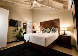 a bedroom with a large bed with a wooden headboard at The Surada Bay in Old Harbour