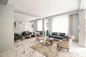a living room with couches and chairs and a table at Irit pyramids inn in Cairo