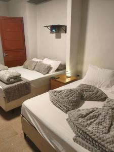 a room with two beds and a light on the wall at Suíte Completa com Tela de Cinema in Garanhuns