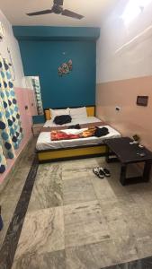 a bedroom with a bed with a blue wall and a table at Hotel Lotus in kolkata