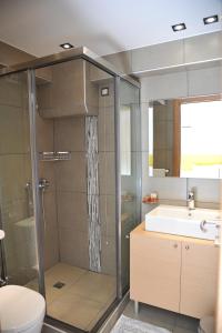 a bathroom with a shower and a toilet and a sink at Elements Rooms & Apartments in Athens