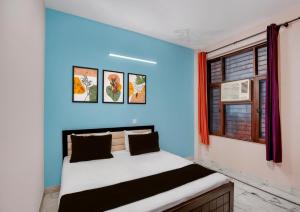 a bedroom with a bed with a blue wall at Shivik stays in Gurgaon