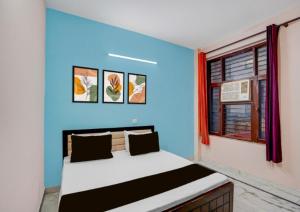 a room with a bed with a blue wall at Shivik stays in Gurgaon +8 photos