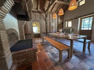 a dining room with a table and a brick fireplace at La landaise in Commensacq