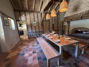 a dining room with a table and a fireplace at La landaise in Commensacq