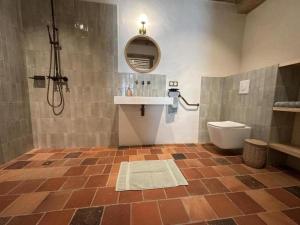 a bathroom with a shower and a toilet and a sink at Le résinier in Commensacq