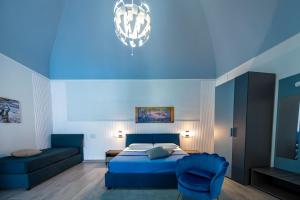 a blue bedroom with a bed and a couch at Domus Alma Pompei in Pompei