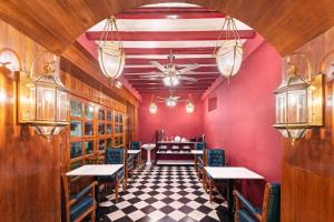 a restaurant with red walls and tables and chairs at Hotel Palais De Versailles in Pondicherry